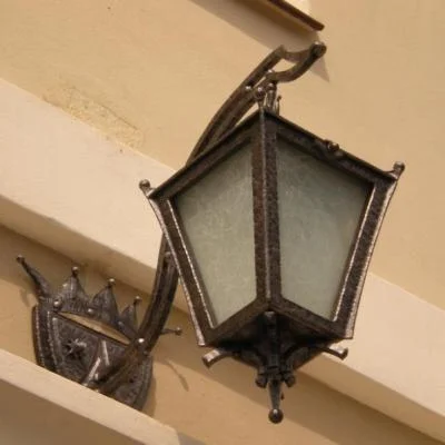 Stylowa kuta lampa zewnętrzna nad portal kościoła w Trutowie. Wyjątkowe kowalstwo historyczne i rekonstrukcja osiemnastowiecznego herbu szlacheckiego. 