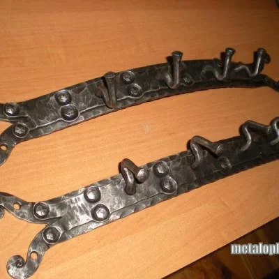 masywne metalowe wieszaki ścienne z dekoracyjnymi ćwiekami, luksusowe akcesoria do przedpokoju w stylu toksańskim. 
