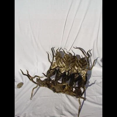 Kosz na szczapy opałowe do kominka,  wykonany w formie gałęzi wyłożonych misternie zdobionymi liśćmi z zachowaniem faktury imitującej żyłki oryginalnego liścia.