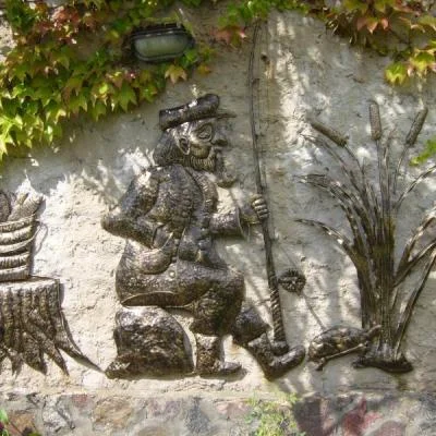 Artystyczna płaskorzeźba ścienna z motywem rybaka, zaprojektowana jako unikatowa ozdoba ogrodu, muru lub ogrodzenia.