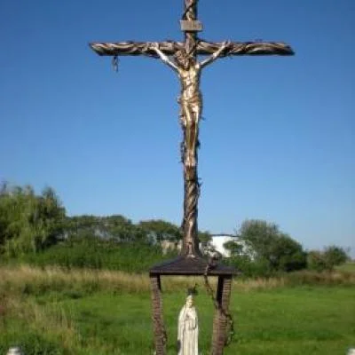 Wielki krzyż przydrożny z figurą Ukrzyżowanego Jezusa i zintegrowaną  kapliczką u podstawy. Metaloplastyka sakralna dedykowana dla parafii oraz miejsc kultu.