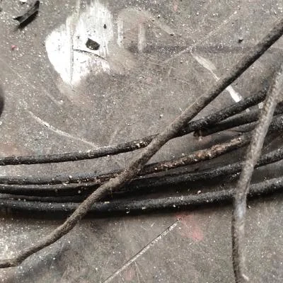 Zdegradowana historyczna instalacja elektryczna zabytkowego kinkietu przed wymianą przewodów podczas prac konserwatorskich.