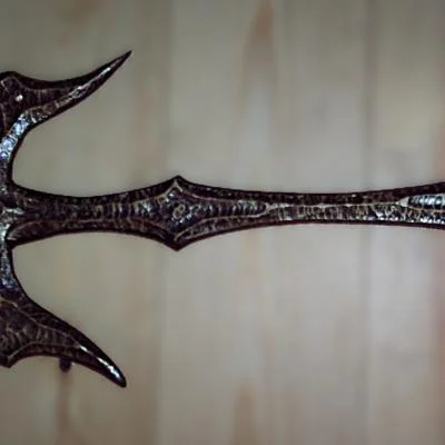 Rękojeść miecza fantasy wykonana ręcznie metodą groszkowania i fakturowania stali, wykończona w kolorze antycznego złota jako autorski detal metaloplastyczny.